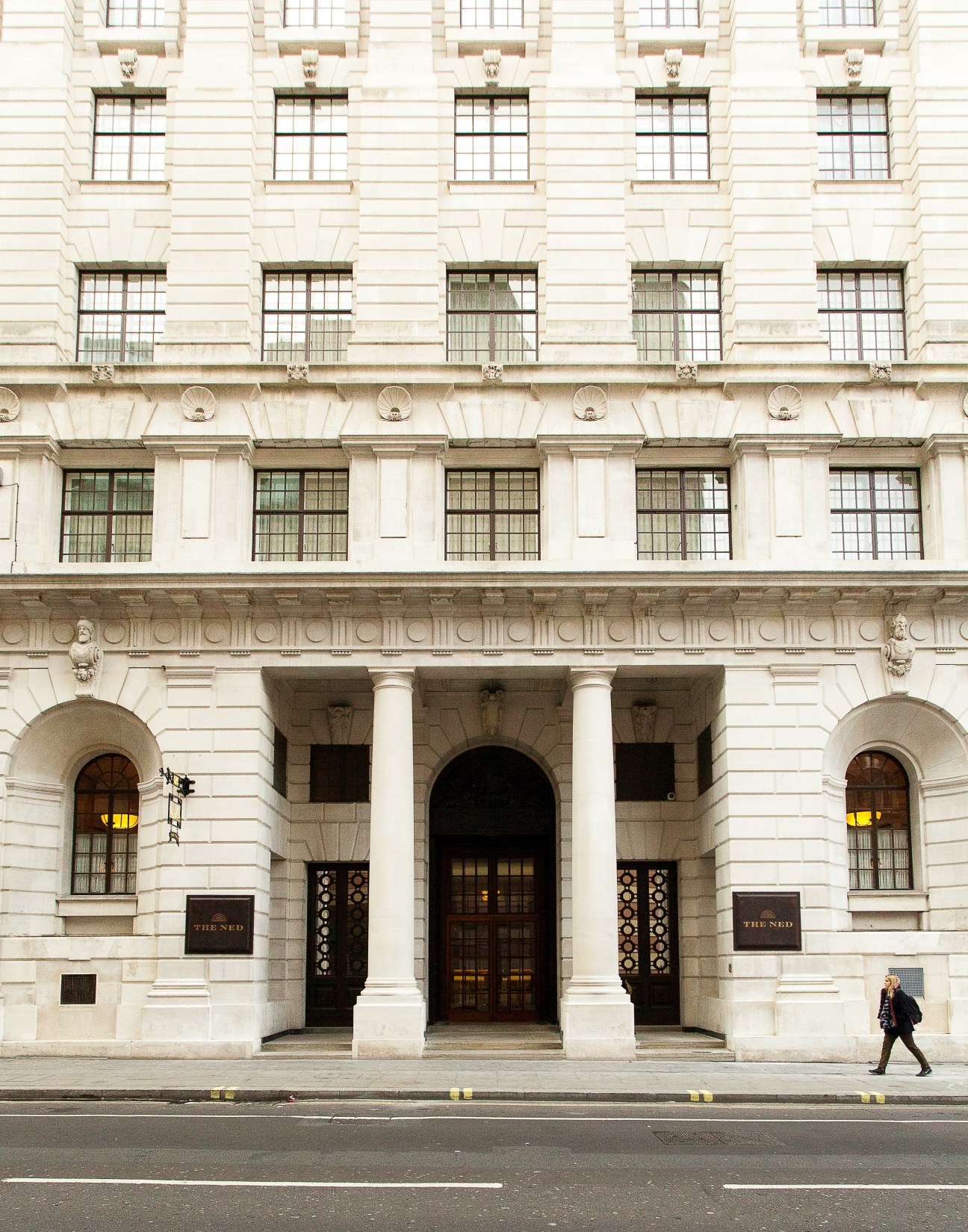 The Ned's Portland stone facade at 27 Poultry with classical columns, arched entrance and symmetrical windows.