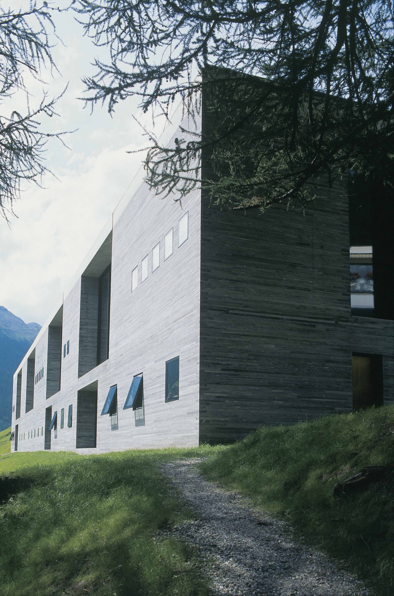 Hotel Therme Vals exterior with modern quartzite stone architecture nestled in Alpine mountains.