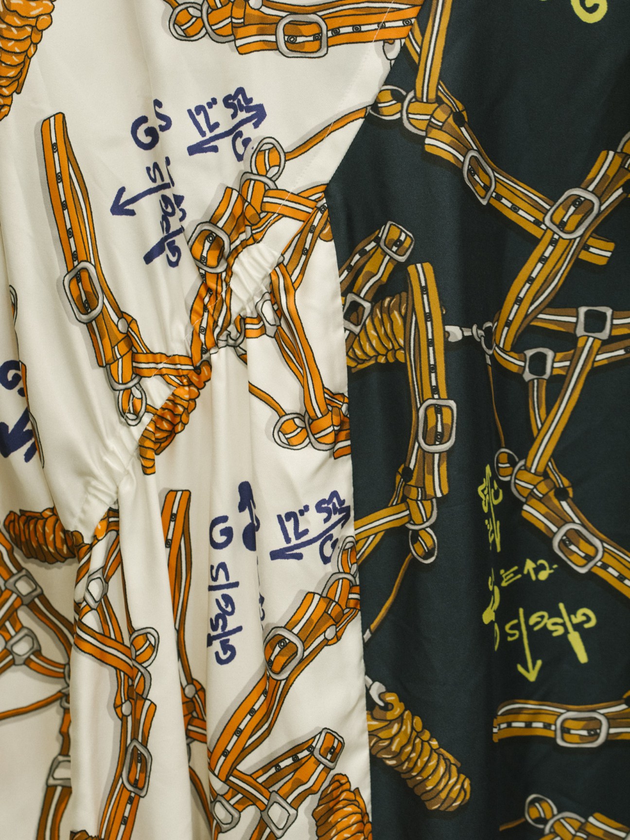 Harness print dresses in cream and black featuring orange strap designs