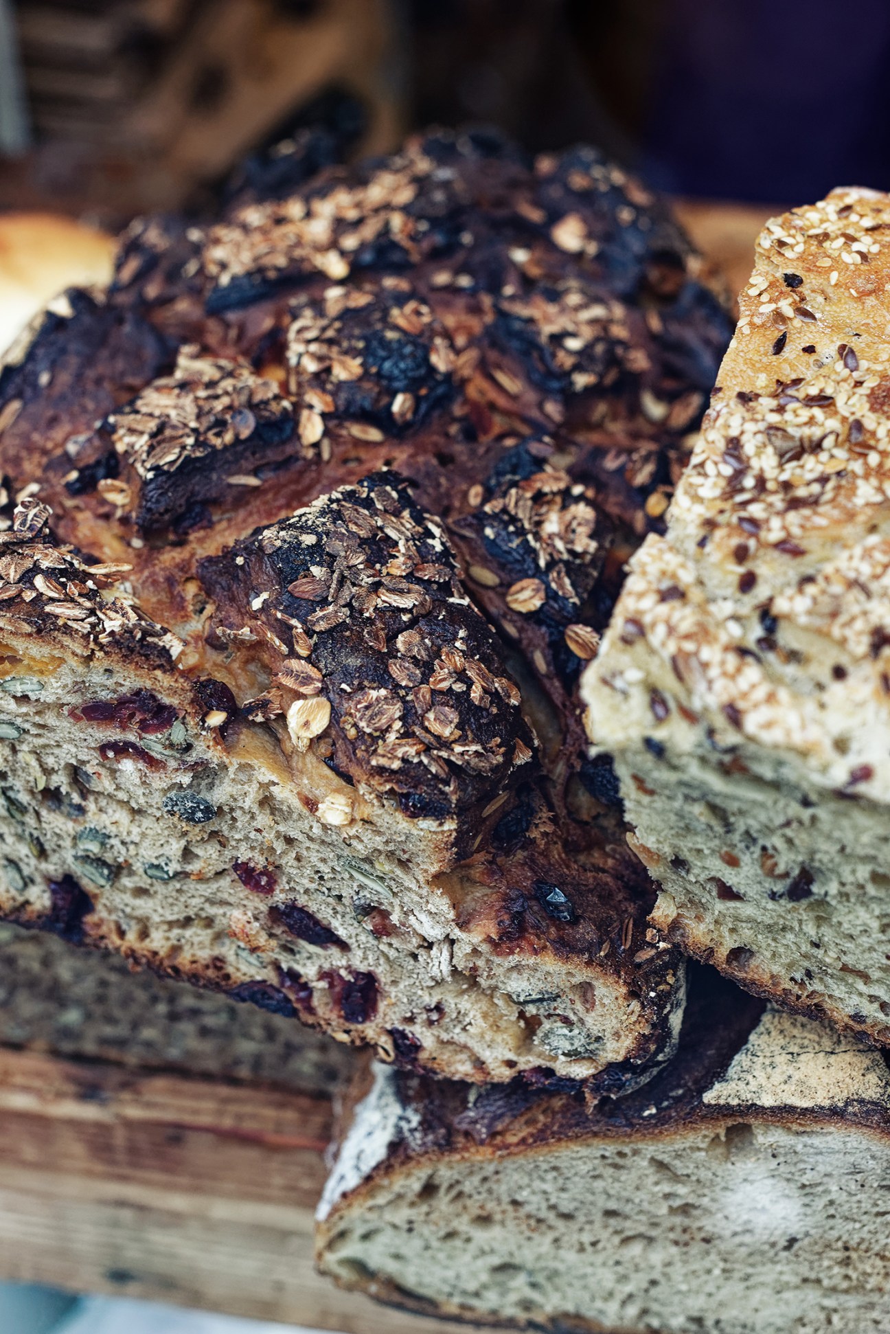 Sliced artisanal bread with seeds and grains visible on the crust and crumb.