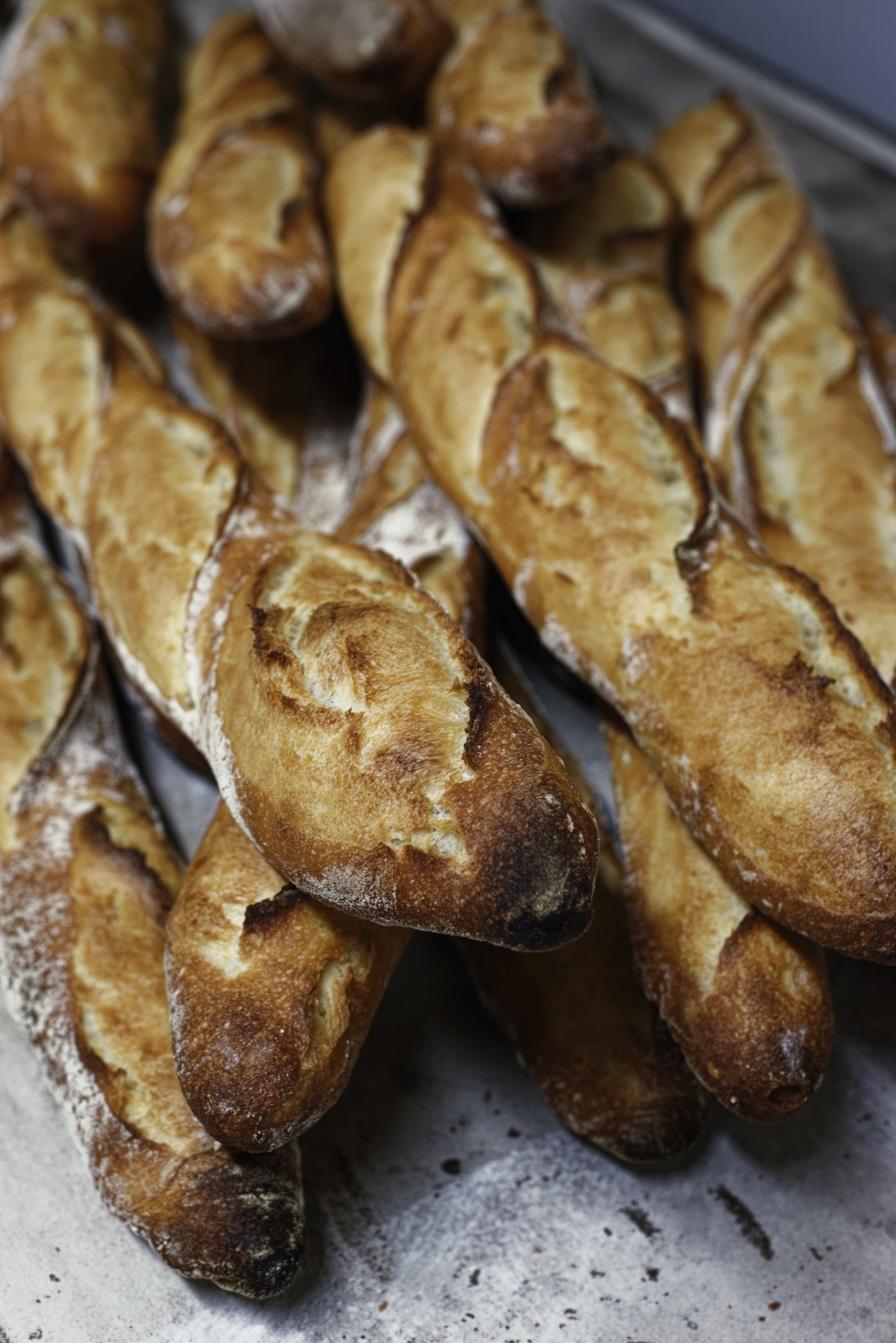 Close-up of fresh crusty baguettes with golden-brown exterior and flour dusting.