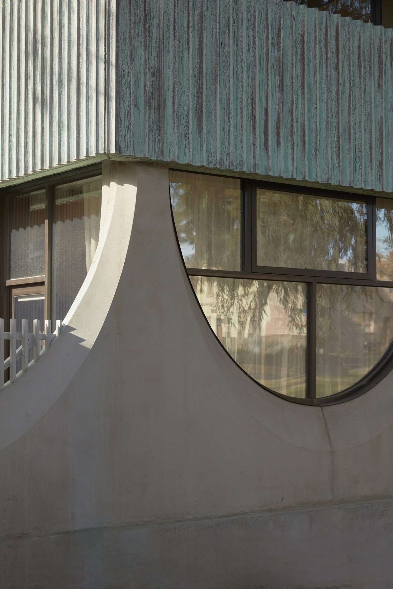 Semi-circular window with black frame on Whitlam Place apartment building exterior.