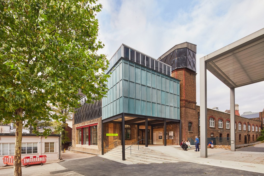 Exterior of Goldsmiths Centre for Contemporary Art showing modern glass and metal addition to Victorian brick building with chimney.