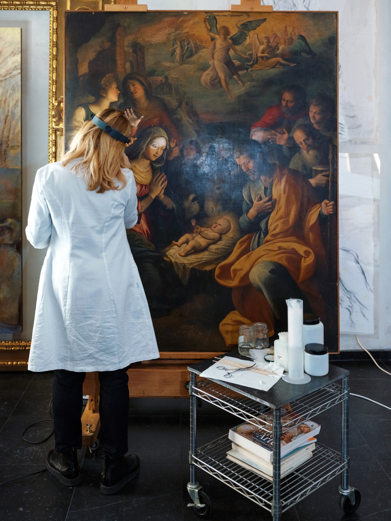 Art restorer Valeria Merlini cleaning a nativity scene painting in her Rome studio.