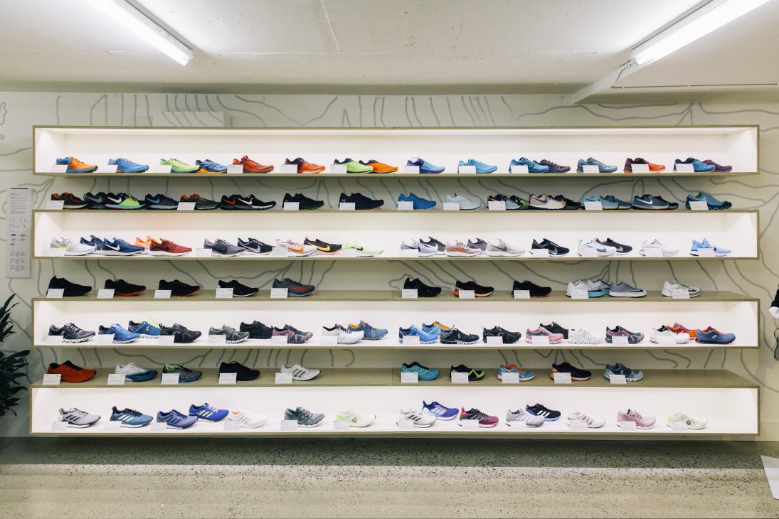Multiple shelves displaying colorful running shoes and trainers at Vancouver Running Co store.