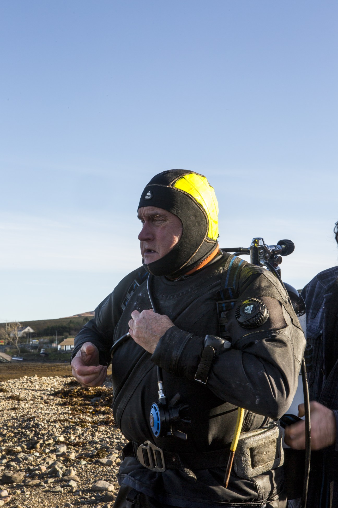 David Oakes in diving wetsuit and yellow helmet suited up for scallop farming on Isle of Skye.