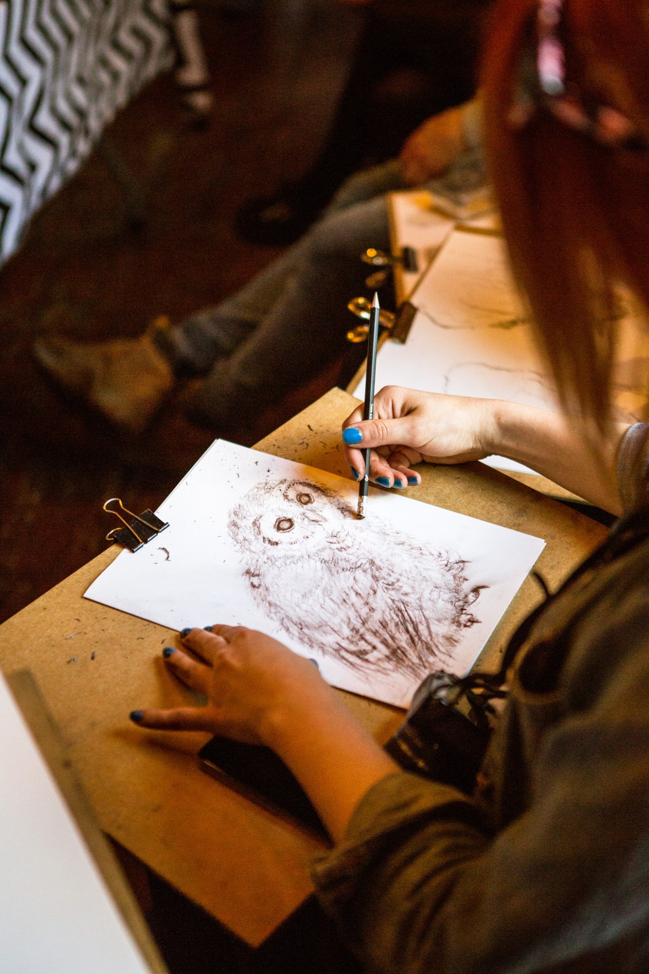 Artist putting finishing touches on drawing of an owl at Wild Life Drawing class