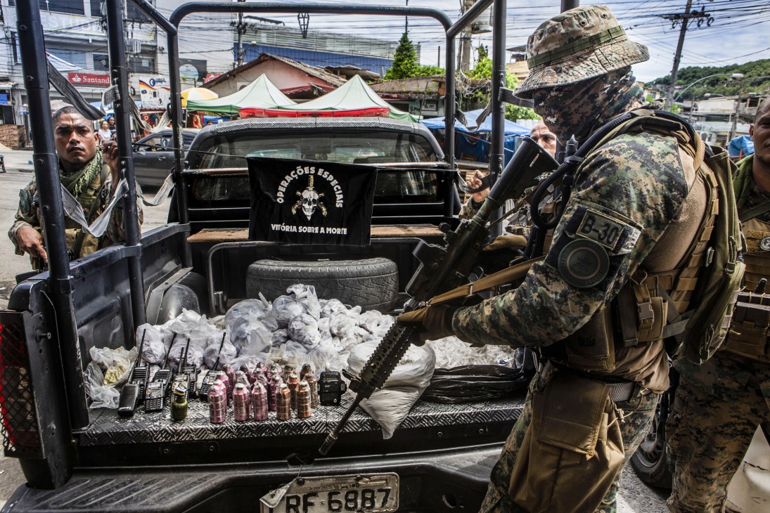 Police Special Operations troops display confiscated drugs, radios and grenades from an anti-trafficking operation.
