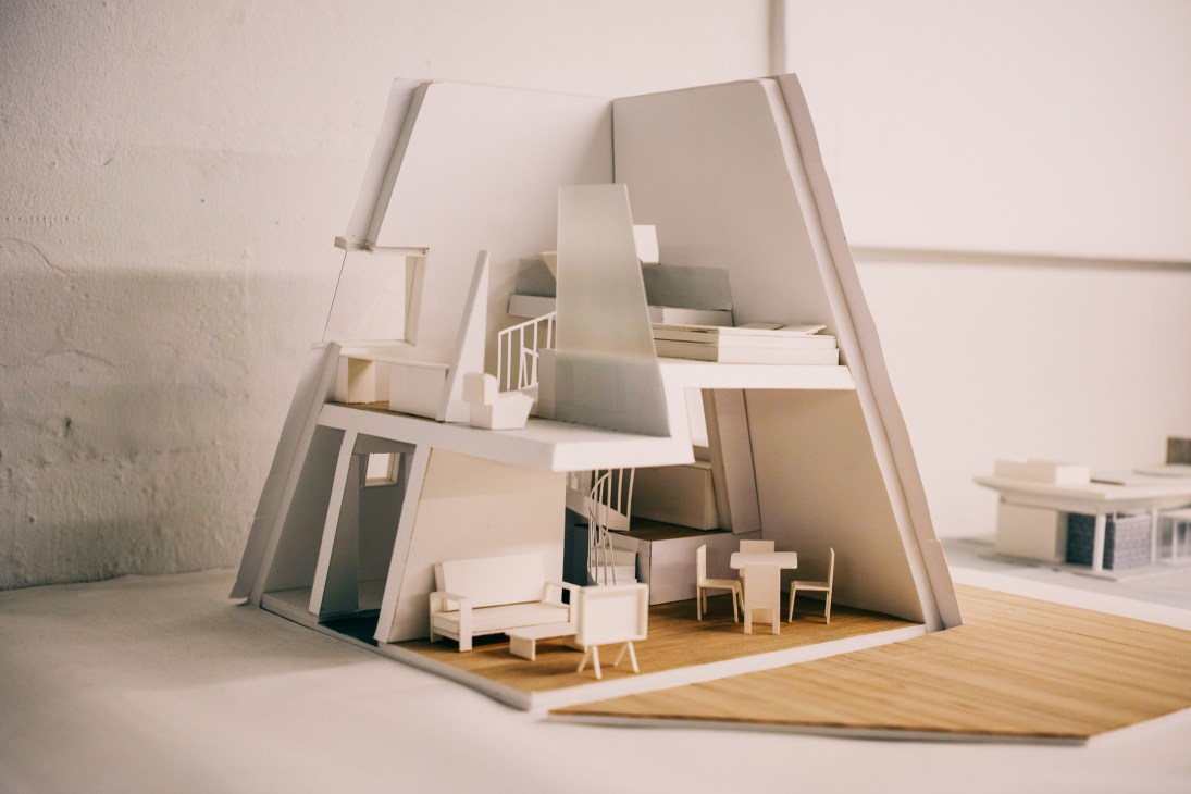 Architectural model of a lodge in Jeju with white walls, wooden flooring, and miniature furniture.